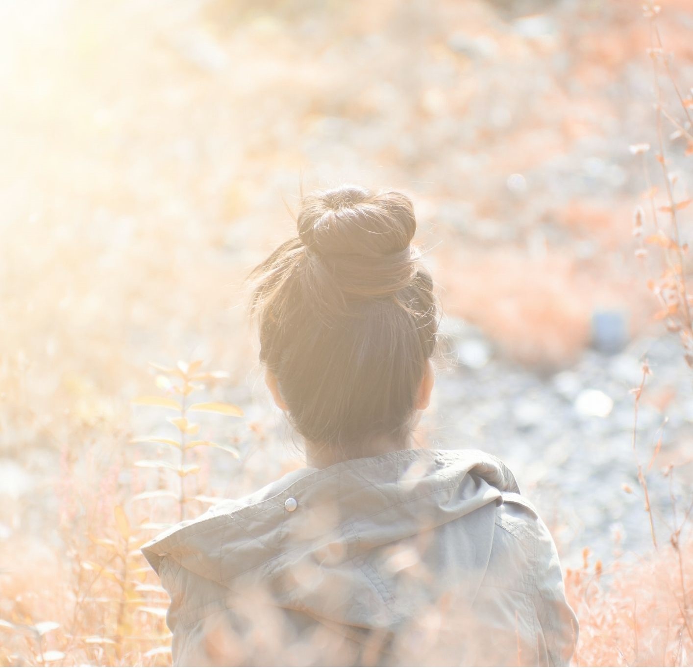 A faded image of a woman looking out into a field like she is contemplating her life